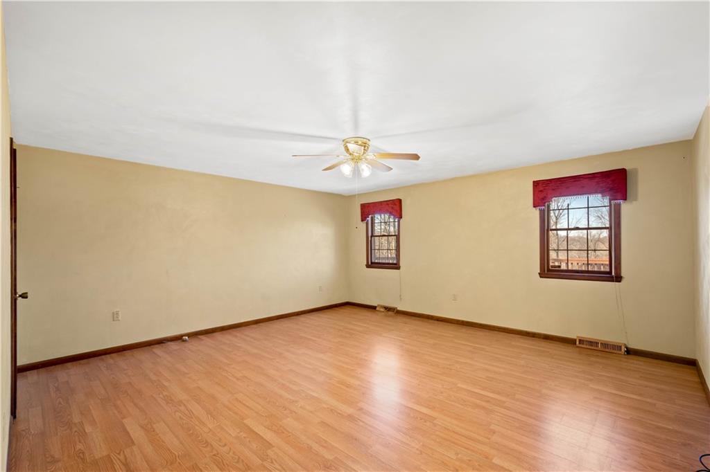 105 Trump Road Cheswick, PA 15024 - Photo 10 of 25 an empty room with a chandelier fan and wooden floor