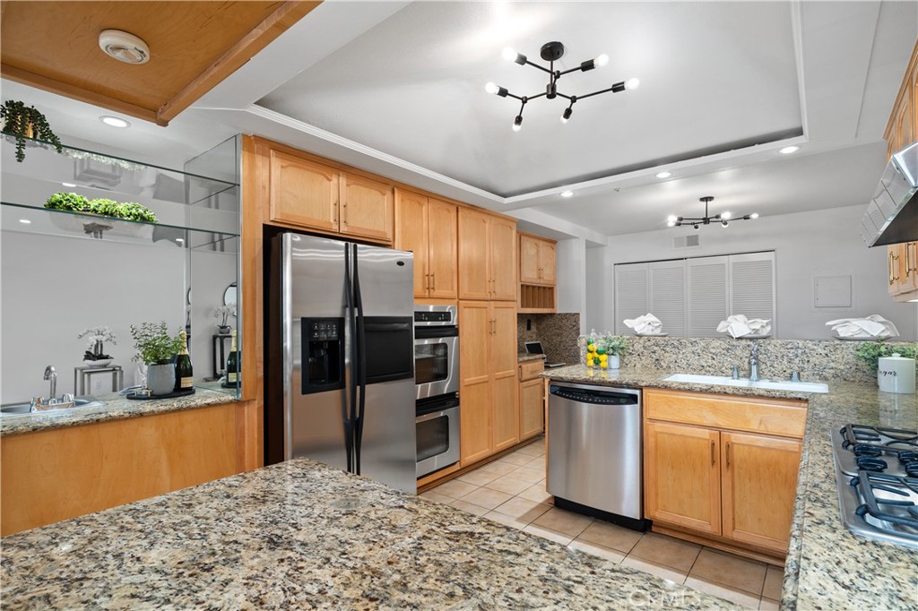 11687 Bellagio Road, Unit 12 Los Angeles, CA 90049 - Photo 14 of 50 The kitchen features access to wet bar, refrigerator, dual ovens, granite countertops, coffered ceiling with integrated lighting, breakfast bar seating, built in desk & wine rack, and more.