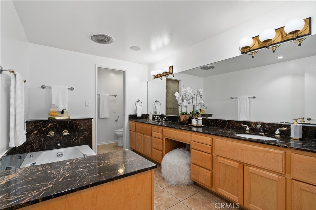 11687 Bellagio Road, Unit 12 Los Angeles, CA 90049 - Photo 23 of 50 The spa inspired bath features an oversized jetted soaking tub, dual sinks with a seated vanity, separate shower area, and private water closet.