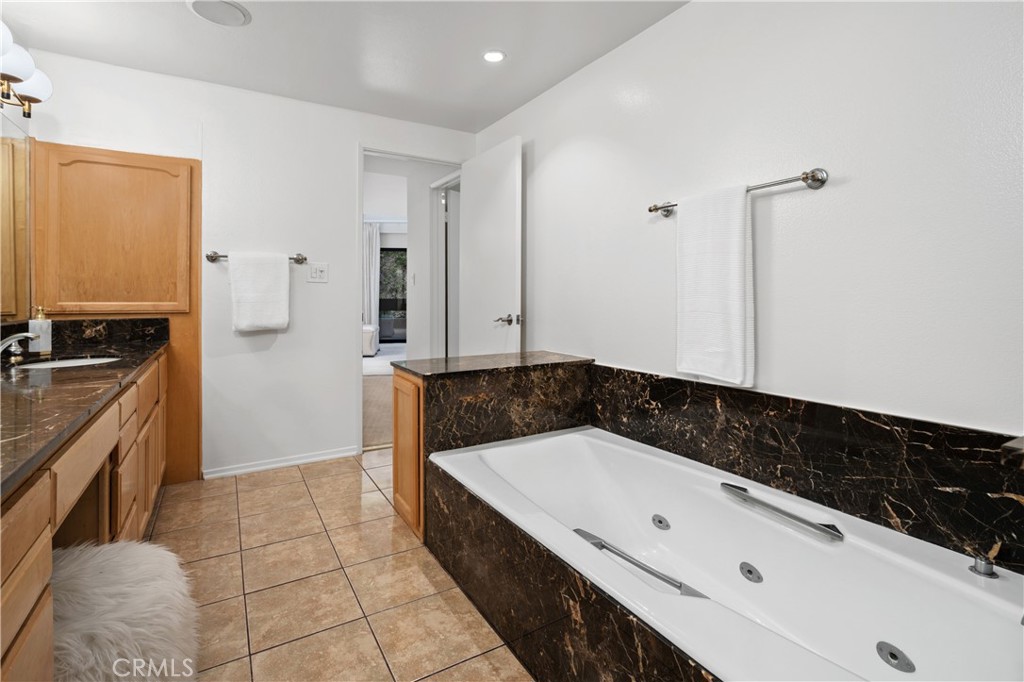 11687 Bellagio Road, Unit 12 Los Angeles, CA 90049 - Photo 24 of 50 The spa inspired bath features an oversized jetted soaking tub, dual sinks with a seated vanity, separate shower area, and private water closet.