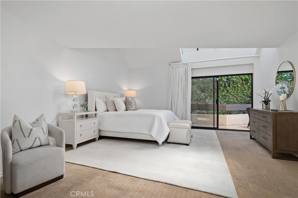11687 Bellagio Road, Unit 12 Los Angeles, CA 90049 - Photo 26 of 50 Double door entry into the large primary bedroom includes high ceiling with skylights and sliding doors out to the back balcony.