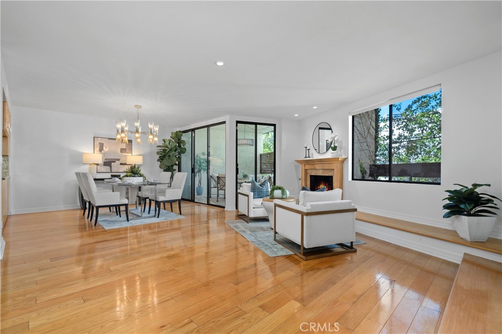 11687 Bellagio Road, Unit 12 Los Angeles, CA 90049 - Photo 7 of 50 A cozy seating area at the fireplace with a generous hearth flows into the formal dining area and out to the front balcony through corner positioned sliding glass doors.