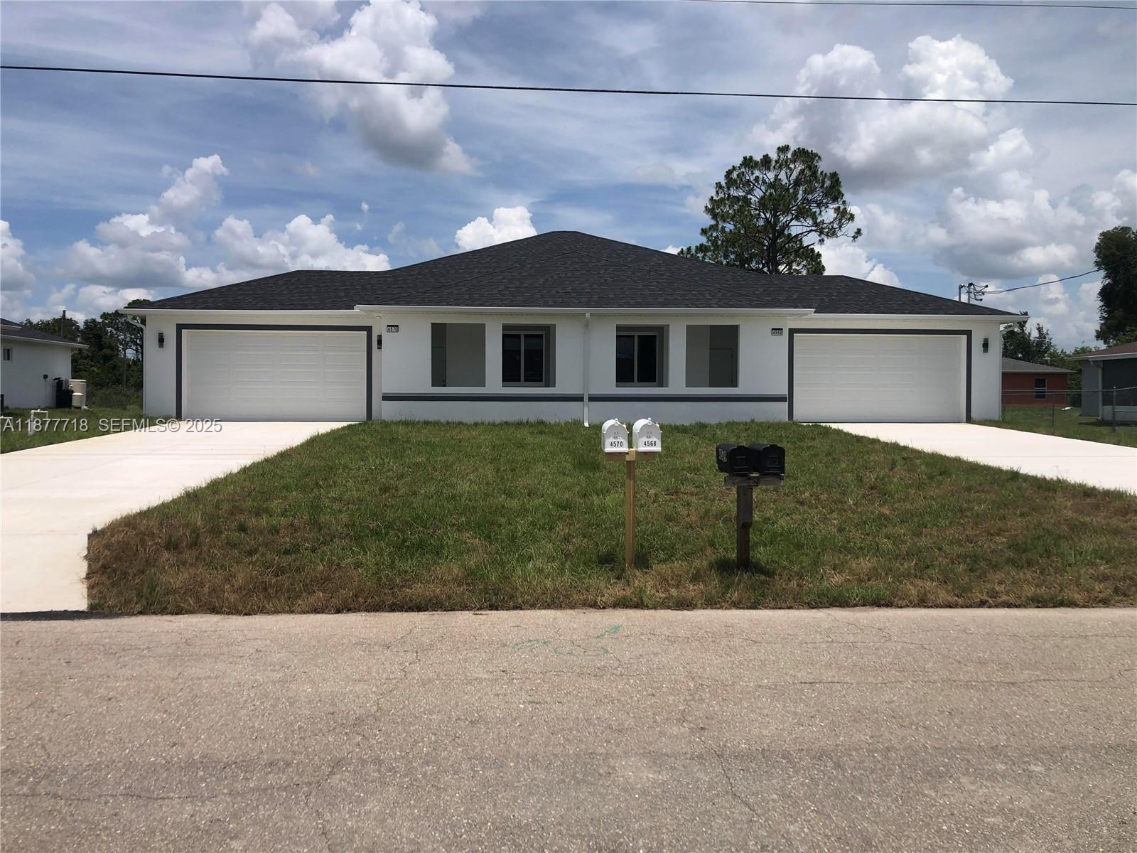 4568 Golfview Boulevard, Unit 1 Lehigh Acres, FL 33973 - Photo 1 of 3 a front view of a house with a yard and garage