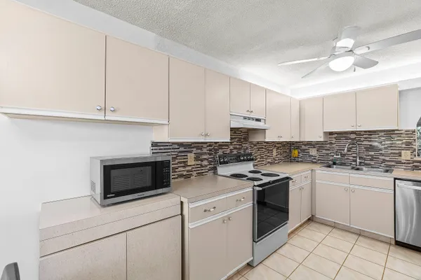 a kitchen with granite countertop white cabinets and white appliances
