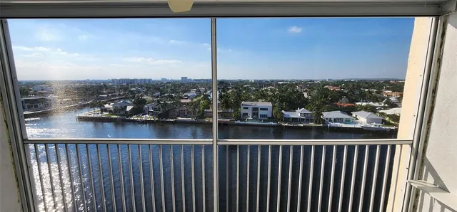 an aerial view of a city with lots of residential buildings ocean and mountain view in back