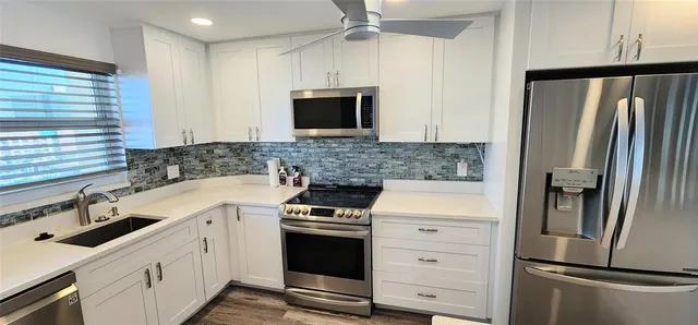 a kitchen with stainless steel appliances granite countertop a refrigerator and a sink