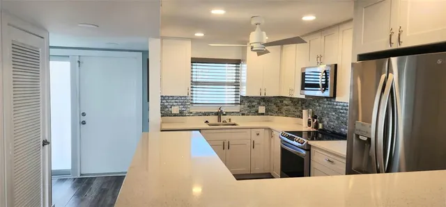 a kitchen with a refrigerator sink and stove