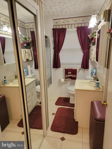 a bathroom with a sink and mirror with bathtub