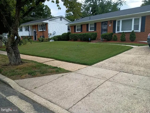 a front view of a house with a yard and trees