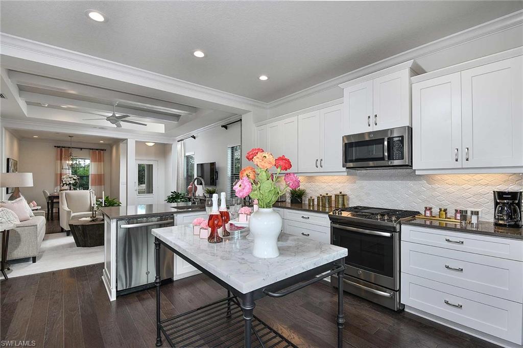 4637 Centaurus Circle Naples, FL 34120 - Photo 11 of 40 a kitchen with stainless steel appliances kitchen island granite countertop a stove refrigerator and cabinets
