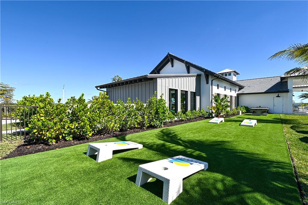4637 Centaurus Circle Naples, FL 34120 - Photo 37 of 40 a backyard of a house with table and chairs plants and large tree