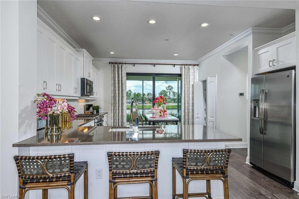 4637 Centaurus Circle Naples, FL 34120 - Photo 8 of 40 a kitchen with stainless steel appliances granite countertop a refrigerator and a dining table