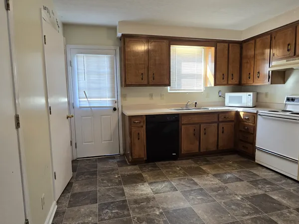 a kitchen with a sink a stove cabinets and refrigerator