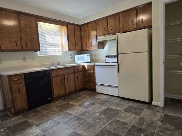 a kitchen with a refrigerator sink and cabinets