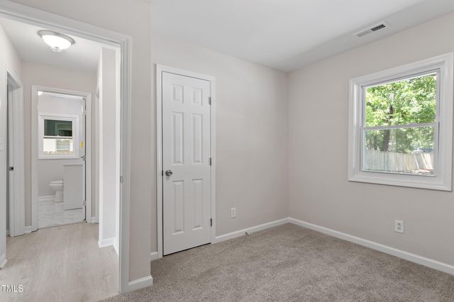 an empty room with windows and closet