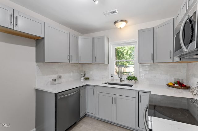 a kitchen with a sink cabinets and a window