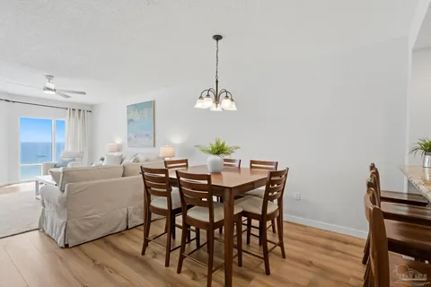 a dining room with furniture a chandelier and wooden floor