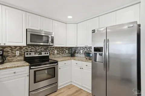 a kitchen with a refrigerator stove and microwave