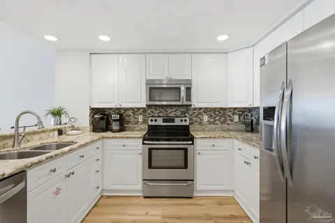 a kitchen with white cabinets and stainless steel appliances