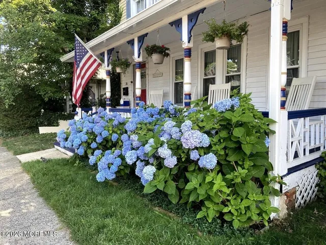 a front view of a house with a yard and garden