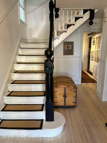 a view of entryway and hall with wooden floor