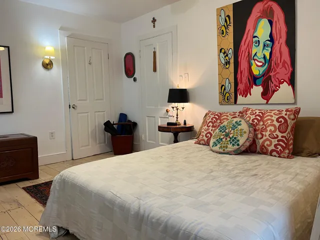 a bedroom with a bed and a painting on the wall
