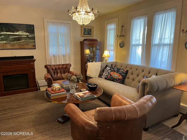a living room with furniture a fireplace and a chandelier