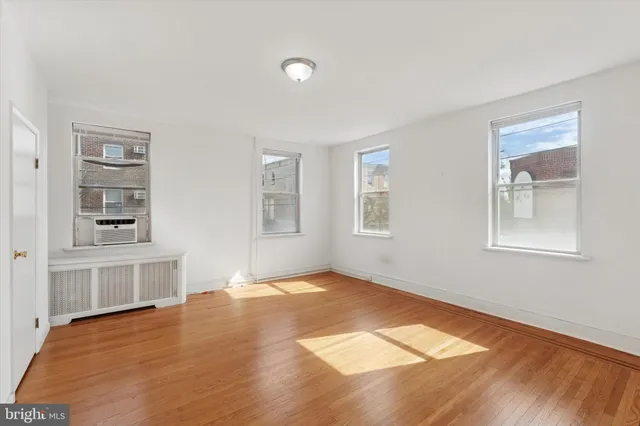 a view of empty room with windows and wardrobe