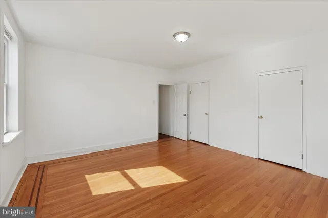 a view of an empty room with wooden floor
