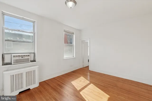 a view of a bedroom with wooden floor