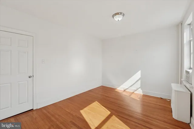 a view of a room with wooden floor and white walls