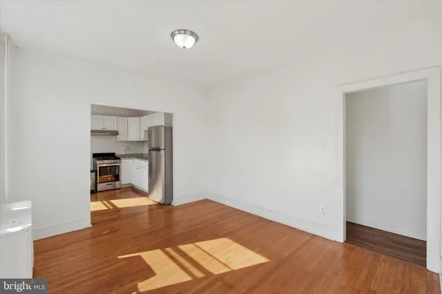 a view of empty room with wooden floor