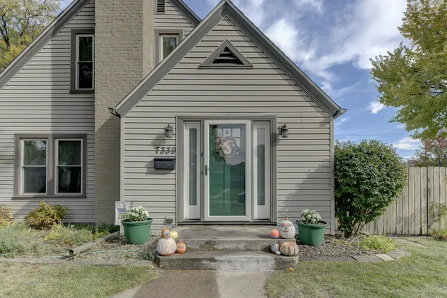 a view of a white house next to a yard