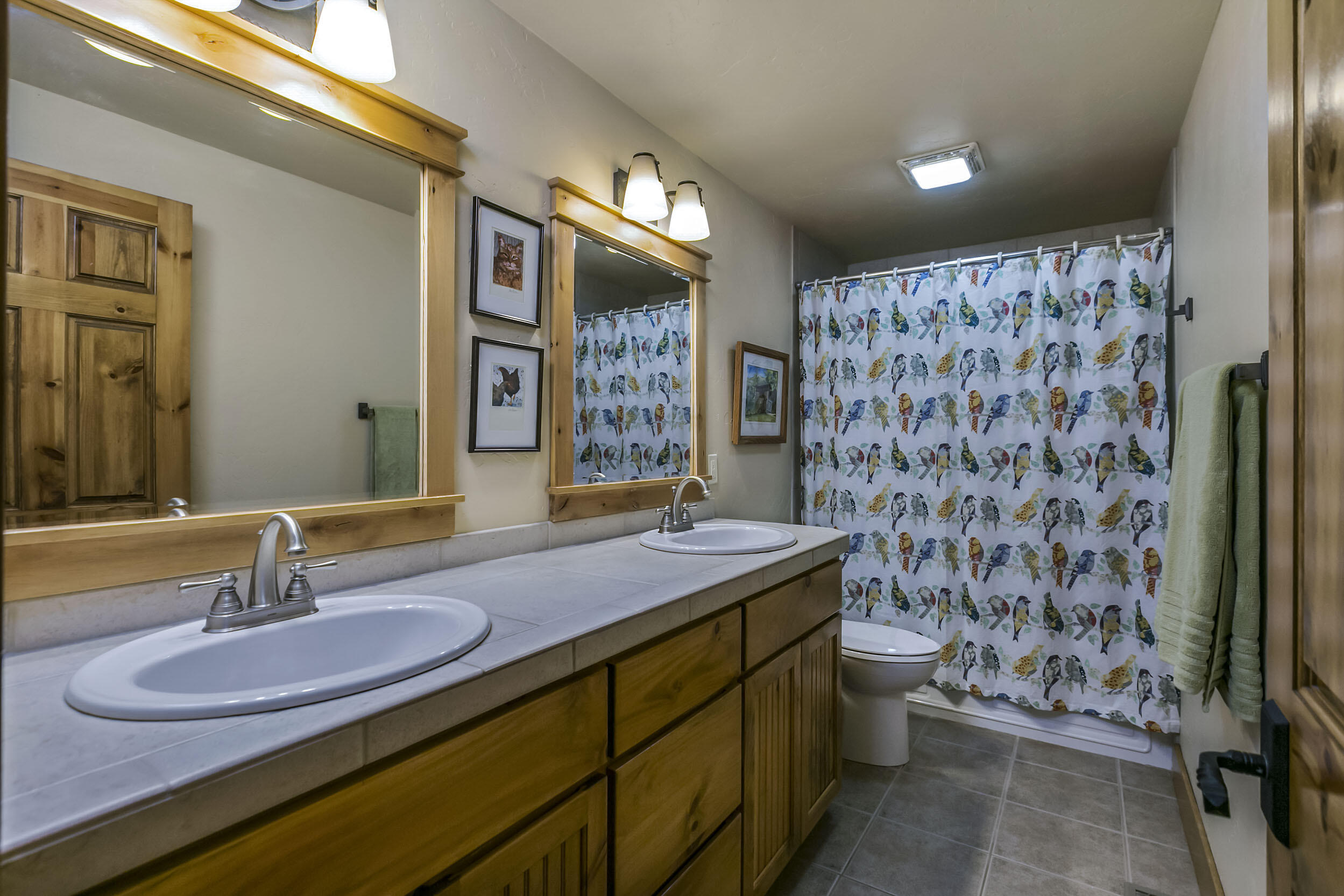 20155 Marsh Road Bend, OR 97703 - Photo 12 of 39 a bathroom with a granite countertop sink a toilet a mirror and shower curtain