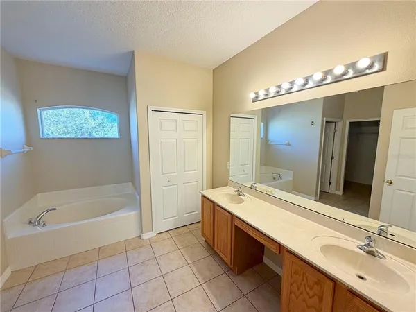 a bathroom with a tub sink and mirror