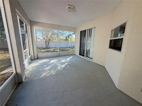 a view of an empty room with a fireplace and a window