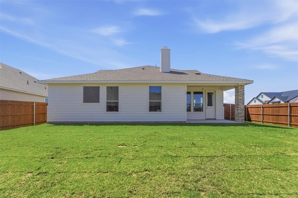 1221 Sabine River Lane Springtown, TX 76082 - Photo 23 of 25 Back of property featuring a patio, a chimney, a shingled roof, and a fenced backyard