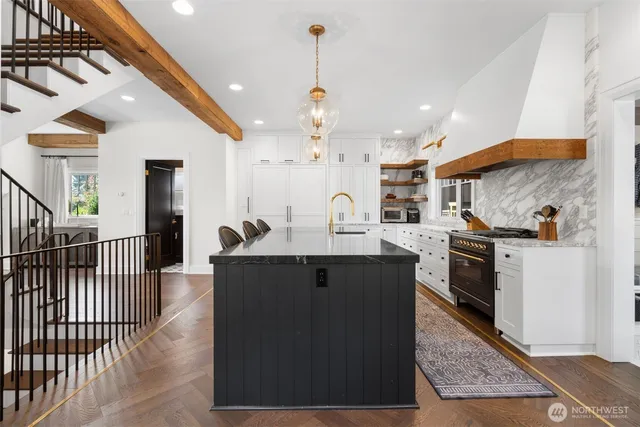 a kitchen with stainless steel appliances granite countertop a stove a sink dishwasher and a refrigerator with wooden floor