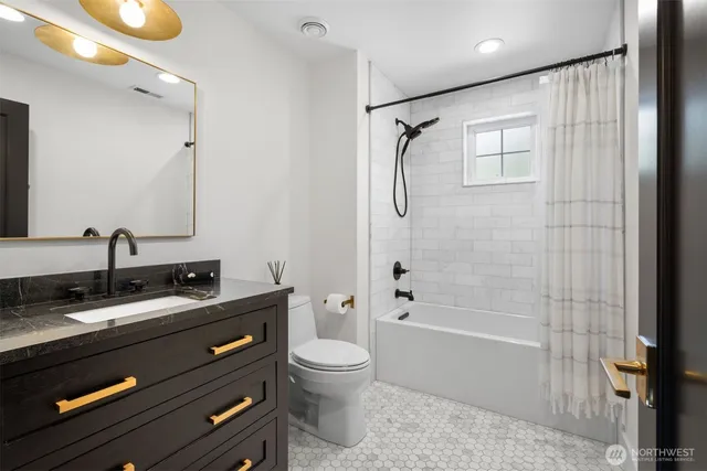 a bathroom with a granite countertop sink a toilet and shower