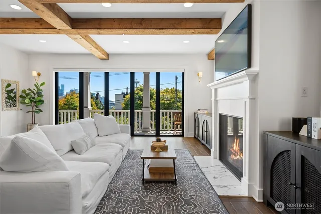 a living room with furniture large windows and a fireplace