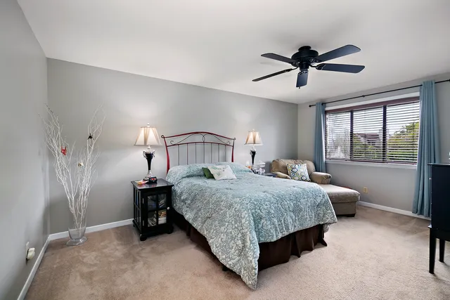 a bedroom with a bed a chandelier and a window