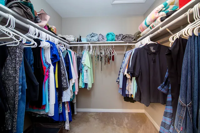 a view of walk in closet with clothes
