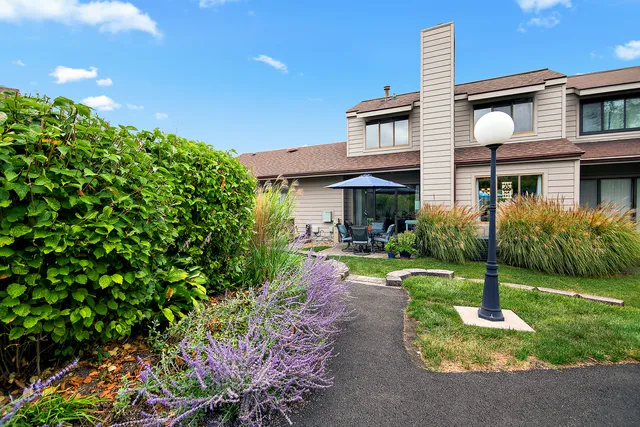a front view of a house with a yard and a garden
