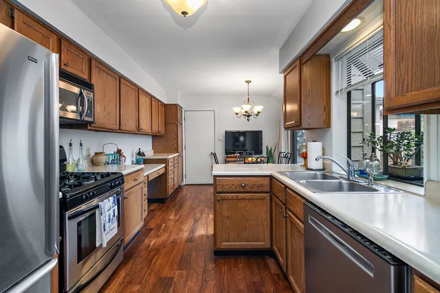 a kitchen with granite countertop a sink a counter space appliances and cabinets