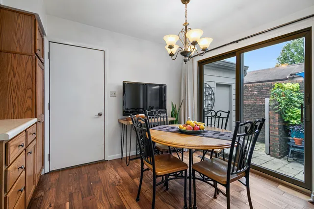 a dining room with furniture a chandelier and wooden floor
