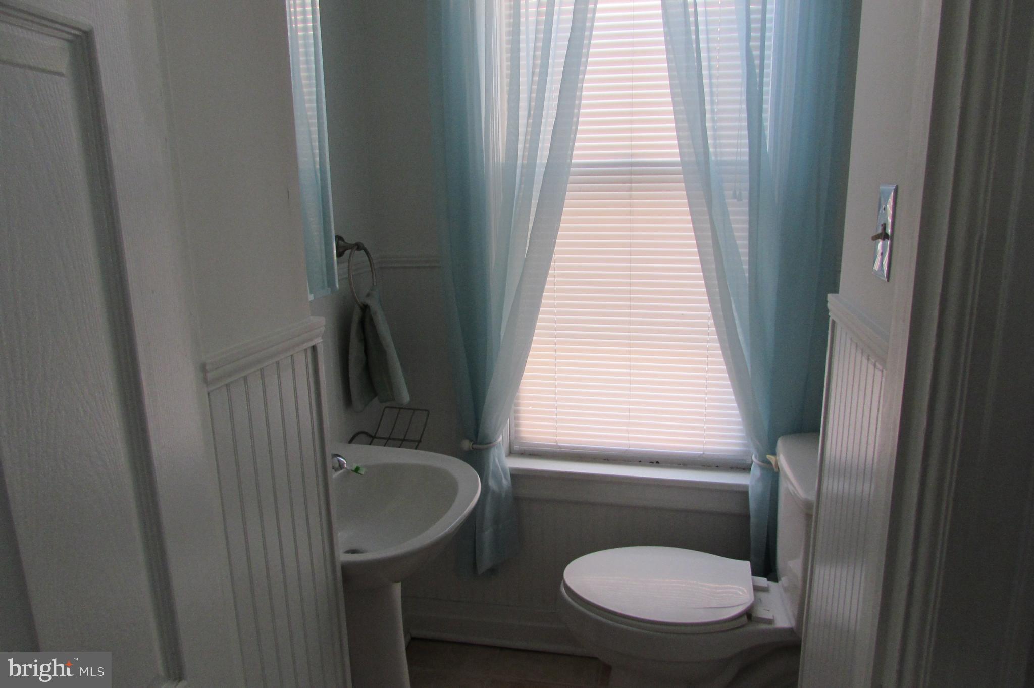 412 South Potomac Street Waynesboro, PA 17268 - Photo 13 of 46 a bathroom with a sink toilet a mirror and window