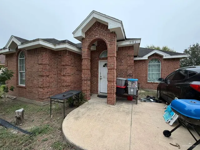 a brick house with a small yard and a large window