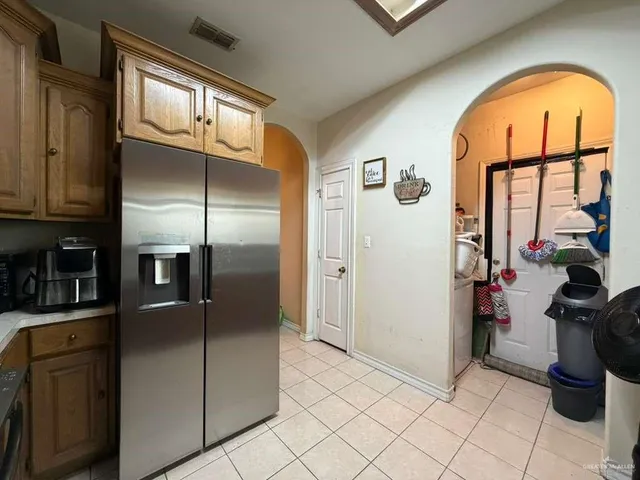 a view of a kitchen with fridge and workspace