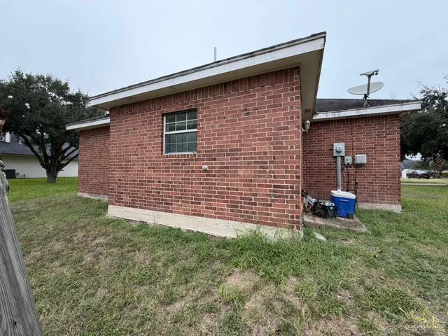 a brick house with garden in front of it