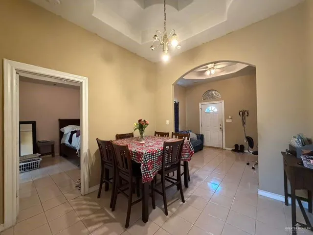 a view of a dining room with furniture and a chandelier fan